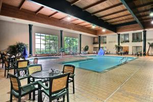 een overdekt zwembad met tafels en stoelen en een tafel en een tabeasteryasteryastery bij Baymont by Wyndham Madison West/Middleton WI West in Madison