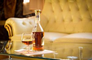 una bottiglia di alcol appoggiata su un tavolo di vetro accanto a un bicchiere di vino di Armenian Royal Palace a Yerevan