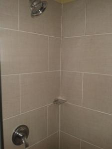a bathroom shower with a tiled shower stall at Believe Caribbean Apartment in Bridgetown