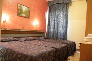 duas camas num quarto de hotel com paredes vermelhas em Hotel Del Sud em Milão