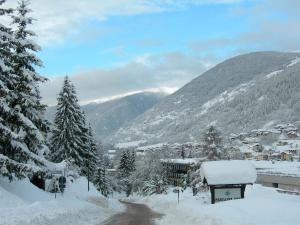 a town covered in snow with mountains in the background at Appartamenti Vacanze Casa Marilleva in Mezzana
