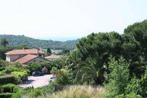 a view of a house and a parking lot with trees at Hotel La Cigale in La Croix-Valmer
