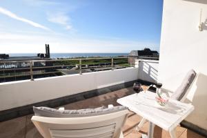 uma varanda com mesa e cadeiras e vista para o oceano em Hotel Wiking Sylt em Westerland