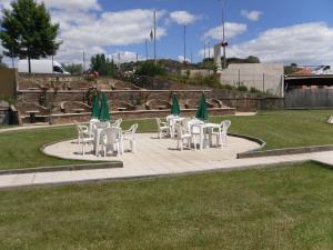 eine Gruppe von Tischen und Stühlen mit grünen Sonnenschirmen in der Unterkunft Grande Hotel Dom Dinis in Mirandela