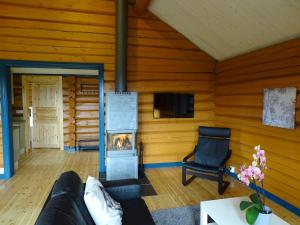 ein Wohnzimmer mit einem Kamin in einer Blockhütte in der Unterkunft Bergsäng Stuga in Leksands-Noret