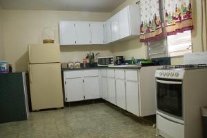 una cocina con armarios blancos y un horno de fogón blanco en Cavernas Guest House, en Quebrada