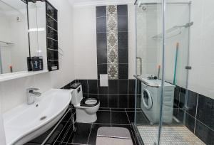 a bathroom with a sink and a toilet and a shower at Studio on Dostyq Street 5 floor 25 in Astana
