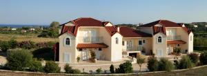 a large house with red roof at Gouna's Aparts in Xi