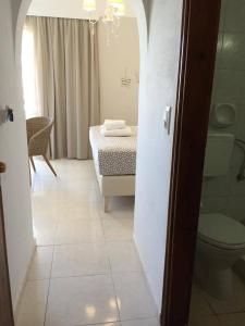 a bathroom with a bed and a toilet in a room at Voula Studios in Faliraki