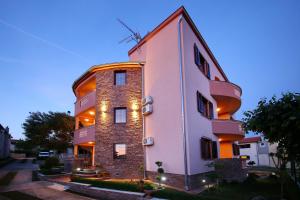 a pink building with lights on the side of it at Villa Dalmatino in Pakoštane