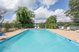 a swimming pool with chairs and a fence at Lake View Inn & Suites in Florence