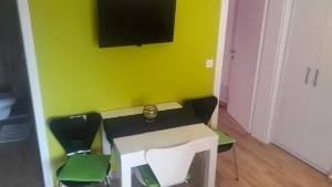 a room with a table with chairs and a tv on the wall at Apartments A&A in Bibinje
