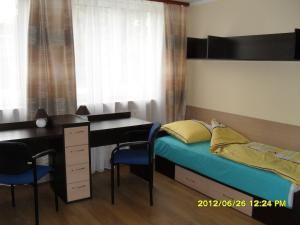 a bedroom with a desk and a bed with a desk and chairs at Dom Studencki Atol in Krakow