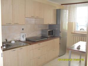 a kitchen with wooden cabinets and a microwave at Dom Studencki Atol in Krakow
