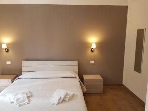 a bedroom with a bed with two towels on it at Il corso Favignana in Favignana +4 photos