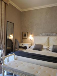 1 dormitorio con cama y banco. en Balneum Boutique Hotel & B&B, en Bagno di Romagna