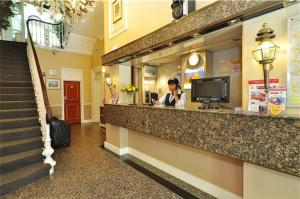 a woman talking on a phone at a counter in a store at Oliver Hotel in London