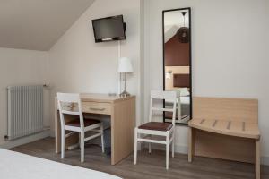 Cette chambre comprend un lit, un bureau et un miroir. dans l'établissement La Bonne Etape, à Amboise