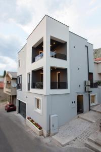 un edificio blanco con balcones en un lateral en Apartments Aida, en Mostar