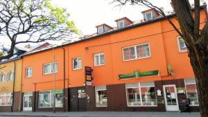 un edificio naranja al lado de una calle en Penzion Exotic, en Ostrava