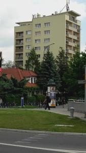 a person walking down a street in front of a tall building at Climate of the 60's in Krakow