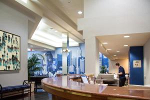 a man standing at a desk in a lobby at Kawada Hotel in Los Angeles