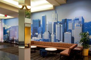 a lobby with a couch and a city mural on the wall at Kawada Hotel in Los Angeles