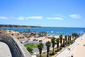 a view of a beach with palm trees and the ocean at RochaBay Apartment in Portimão