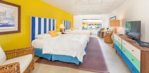 a bedroom with two beds and a flat screen tv at Bimini Big Game Club Resort & Marina in Alice Town