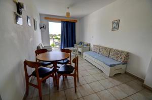 a living room with a couch and a table and chairs at Renos Apartments in Polis Chrysochous