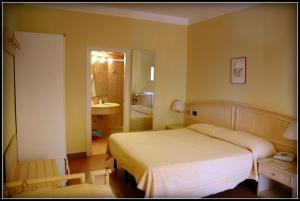 a bedroom with a large bed and a bathroom at Hotel Viticcio in Portoferraio +37 photos