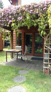 a patio with a table and a bunch of flowers at Nestledown B&B in Halfmoon Bay