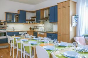 eine Küche mit einem Tisch mit Stühlen und blauen Schränken in der Unterkunft Villa Ginia in Locarno