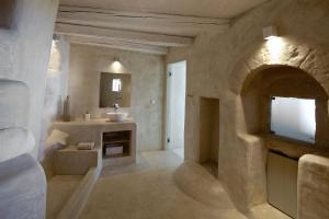 a large bathroom with a sink and a mirror at MELANOPETRA boutique apartments in Emporeiós