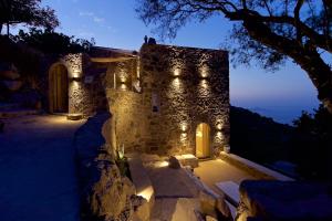 a stone building with lights on it at night at MELANOPETRA boutique apartments in Emporeiós