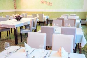 a dining room with white tables and chairs at Hotel Olympia in Axamer Lizum