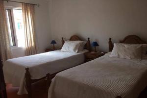 sypialnia z 2 łóżkami i oknem w obiekcie Casa do Moinho w mieście Santa Cruz