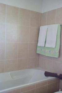 a bathroom with a bath tub and towels on a wall at Casa do Moinho in Santa Cruz