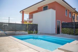 a swimming pool in front of a house at Casa Pepe in Colà di Lazise