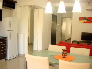 cocina con mesa, sillas y nevera en Rent Apart Caballito 3 en Buenos Aires