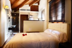 Un dormitorio con una cama blanca con rosas rojas. en El Cierzo de Javalambre, en Arcos de las Salinas