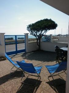 新福卡的住宿－Villino sul mare，阳台上摆放着两把椅子和一张桌子,还有一棵树