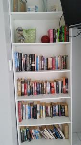 a book shelf filled with lots of books at Sunset Quay in Rarotonga