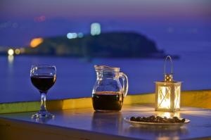 een tafel met een glas wijn en een drankje bij Hotel Grotta in Naxos Chora