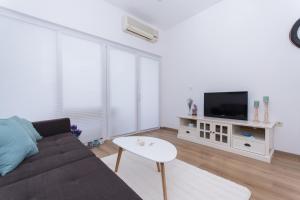 a living room with a couch and a tv at Lavanda in Kaštela