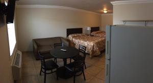 Habitación de hotel con mesa, cama y nevera. en Sunset Motel, en Seaside Heights