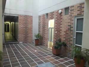 a hallway of a brick building with potted plants at Hotel Valle de Beraca in Cúcuta