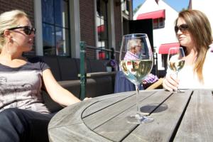 Due donne sedute a un tavolo con bicchieri da vino di Hotel Medemblik a Medemblik