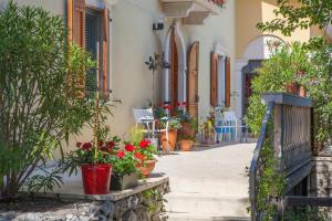 une passerelle avec des plantes en pot sur le côté d'un bâtiment dans l'établissement Villa Borgo Duino, à Duino