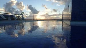 uma piscina vazia com o pôr-do-sol ao fundo em Apartamento Tambau a Beira Mar em João Pessoa